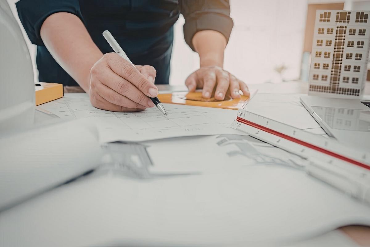 Progettazione immobile — tavolo di lavoro del geometra con planimetrie
